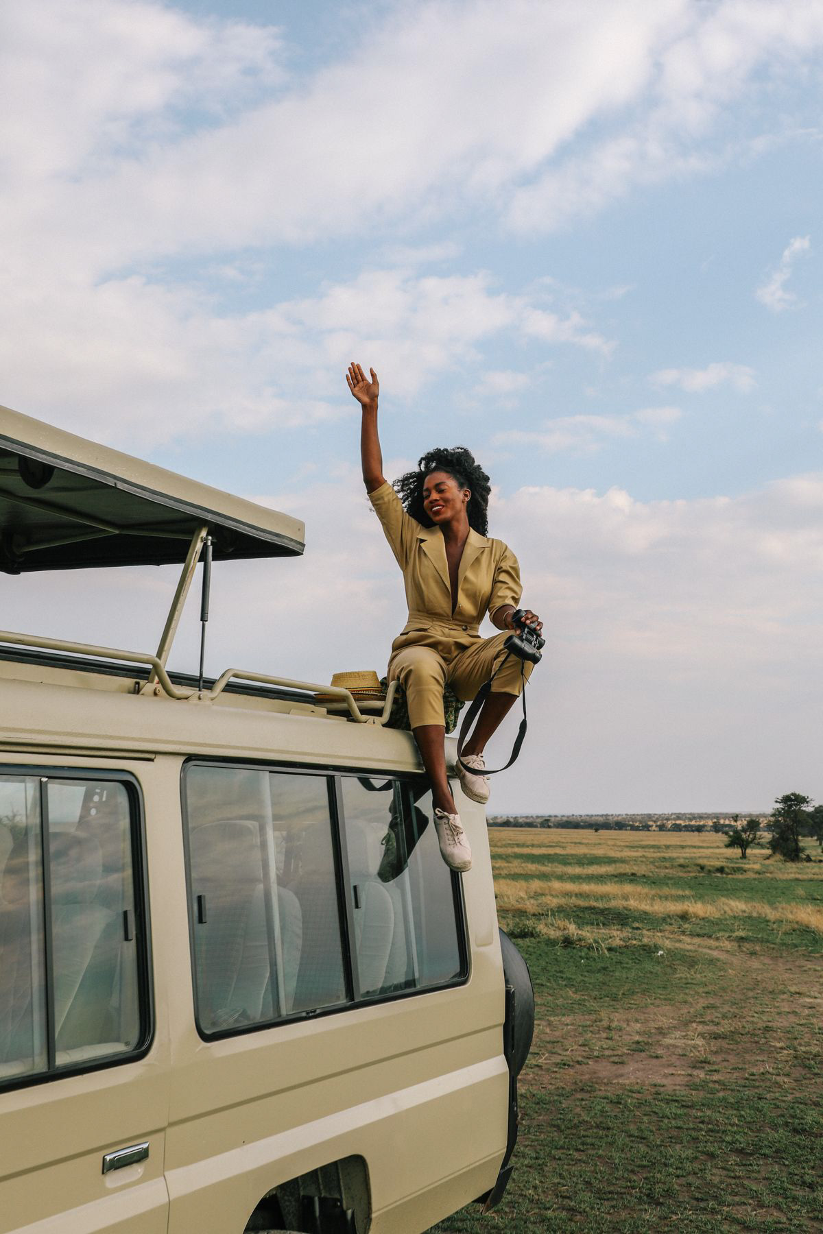 a woman going wild on top of a lancruiser with pop-up roof-top